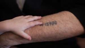Ein Holocaust-Überlebender zeigt seinem Enkel die auf seinen Arm tätowierte Häftlingsnummer, Jerusalem, 24. Mai 2013. Foto: Yonatan Sindel/Flash90.