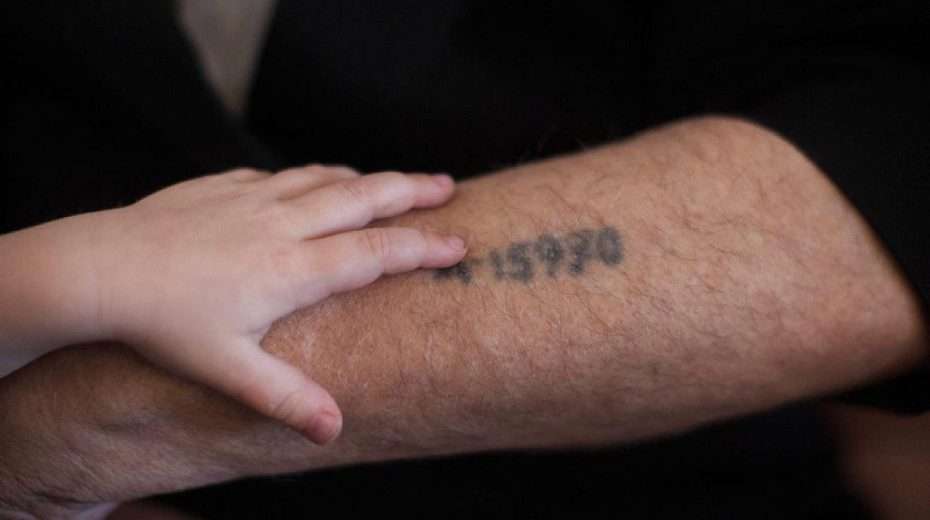 Ein Holocaust-Überlebender zeigt seinem Enkel die auf seinen Arm tätowierte Häftlingsnummer, Jerusalem, 24. Mai 2013. Foto: Yonatan Sindel/Flash90.