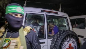 Ein Hamas-Terrorist übergibt israelische Geiseln an das Rote Kreuz in Rafah, im südlichen Gazastreifen, 28. November 2023. Kredit: Flash90.