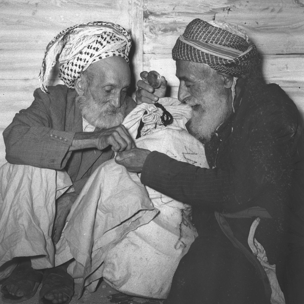 Zwei ältere jüdische Männer warten auf ihre Registrierung, nachdem sie 1950 aus dem Irak nach Israel ausgeflogen wurden. Juden hatten seit dem babylonischen Exil vor 2.500 Jahren in Mesopotamien gelebt. Foto von Hans Pinn/GPO