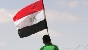 Ein palästinensischer Mann hisst eine ägyptische Flagge an der Grenze zwischen dem Sinai und Gaza. Foto von Abed Rahim Khatib/Flash90