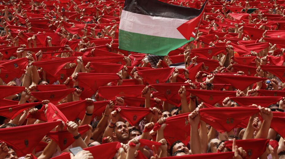 Eine Person schwenkt eine palästinensische Flagge, während die Menschen auf den Start der Chupinazo-Rakete warten, die den Beginn der San Fermin-Festlichkeiten in Pamplona, Spanien, am 6. Juli 2025 markiert. EPA/Villar Lopez