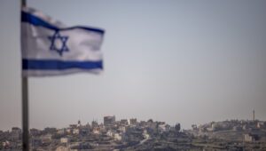 Eine israelische Flagge in der israelischen Siedlung Kedumim ist im Vordergrund eines palästinensischen Dorfes im Westjordanland zu sehen. 7. Januar 2025. Foto: Chaim Goldberg/Flash90