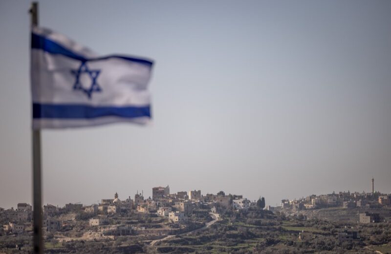 Eine israelische Flagge in der israelischen Siedlung Kedumim ist im Vordergrund eines palästinensischen Dorfes im Westjordanland zu sehen. 7. Januar 2025. Foto: Chaim Goldberg/Flash90