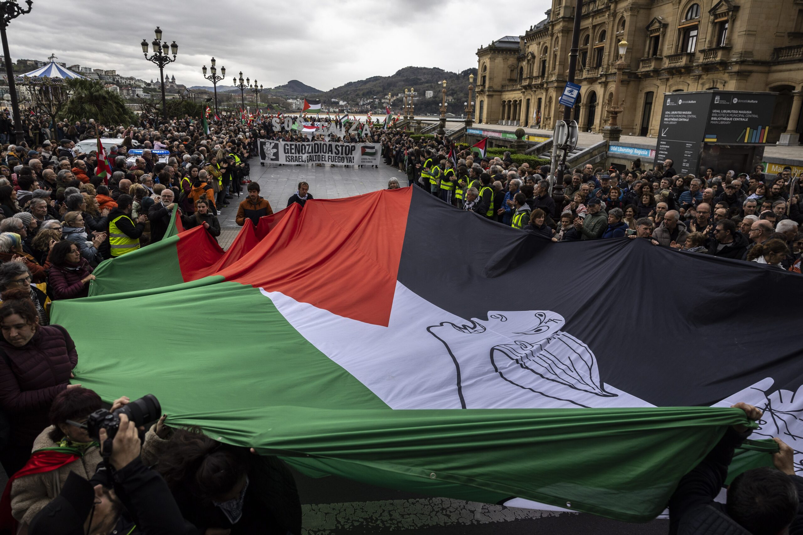 Menschen halten während einer Demonstration in San Sebastian, Spanien, am 22. März 2025 eine riesige palästinensische Flagge hoch, um das