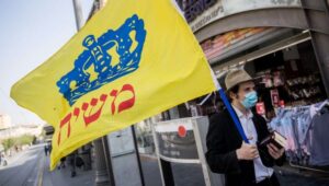 Ein Chabad-Anhänger trägt eine Flagge mit der Aufschrift „Messias“ durch die Straßen Jerusalems. Foto: Yonatan Sindel/Flash90