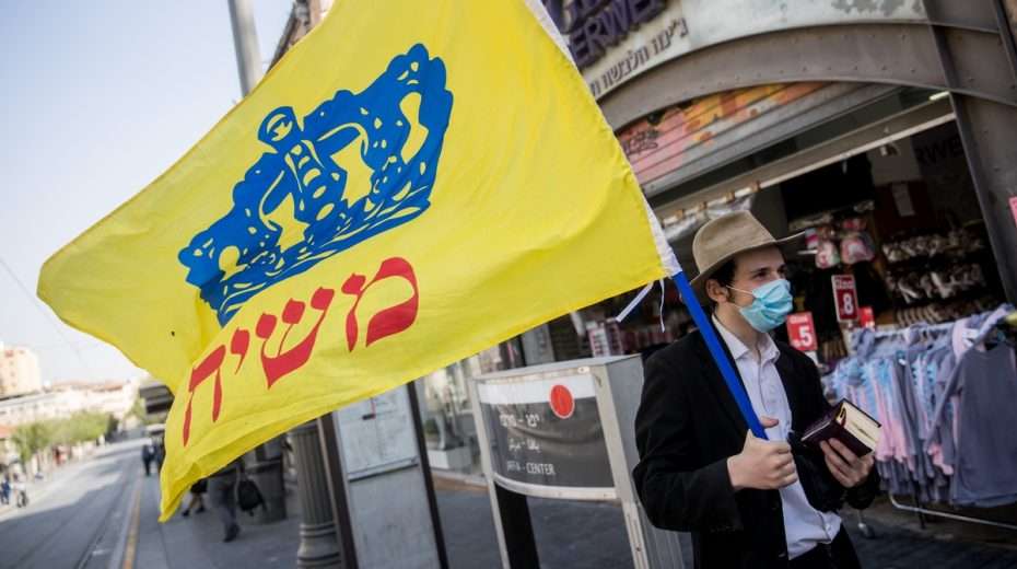 Ein Chabad-Anhänger trägt eine Flagge mit der Aufschrift „Messias“ durch die Straßen Jerusalems. Foto: Yonatan Sindel/Flash90