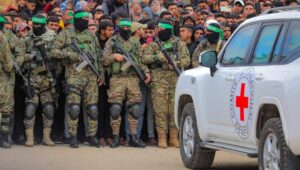 Hamas-Terroristen übergeben drei männliche israelische Geiseln an das Rote Kreuz als Teil des Waffenstillstandsabkommens zwischen Jerusalem und der islamistischen Gruppe in Deir al-Balah im Gazastreifen am 8. Februar 2025. Foto: Ali Hassan/Flash90.
