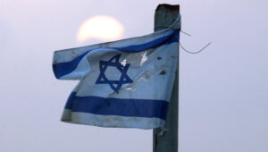 Eine zerrissene israelische Flagge weht bei Sonnenuntergang in der Siedlung Chavat Gilad. Foto: Nati Shohat, Flash90