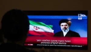 Eine Person verfolgt am 12. März 2026 im Moshav Mishmar David eine Fernsehsendung, in der eine Botschaft des neuen obersten Führers des Iran, Ayatollah Mojtaba Khamenei, an die internationale Gemeinschaft gezeigt wird. Foto: Nati Shohat/Flash90.