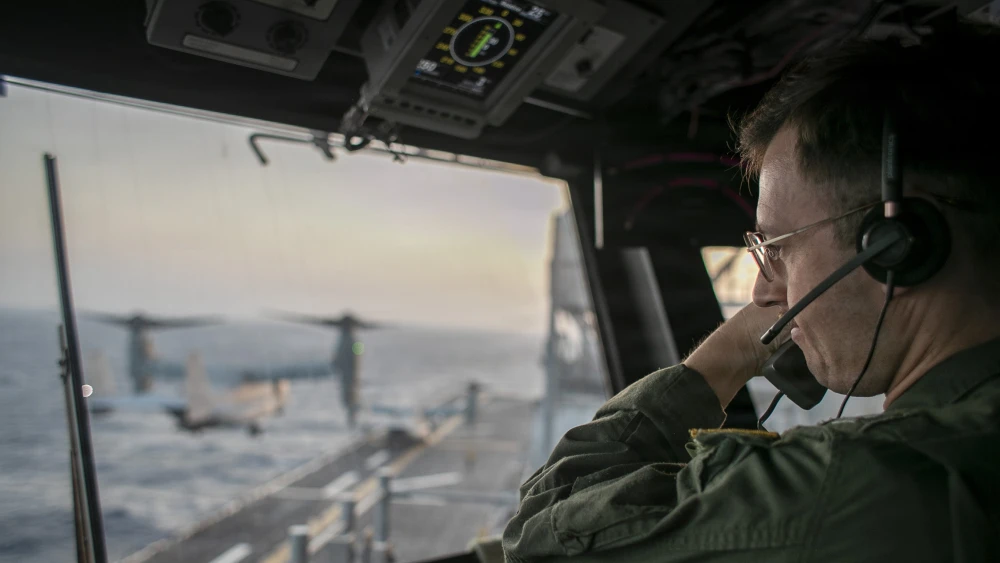 Ein Marineoffizier an Bord der USS Tripoli überwacht vom Kontrollturm aus den Flugbetrieb, während das amphibische Angriffsschiff im Rahmen der Durchsetzung einer Seeblockade gegen den Iran im Arabischen Meer kreuzt und gleichzeitig das „Projekt Freedom“ zur Unterstützung des freien Handelsverkehrs durch die Straße von Hormus durchführt, Mai 2026. Bildnachweis: US Navy.
