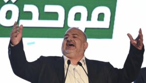 Der Vorsitzende der Vereinigten Arabischen Liste (Ra'am), Mansour Abbas, steht neben seinen Parteikollegen auf der Bühne nach der Veröffentlichung der Nachwahlbefragungsergebnisse in der nordisraelischen Stadt Sakhnin, in der Wahlnacht der israelischen Parlamentswahl am 27. Oktober 2026. Foto von Michael Giladi/Flash90